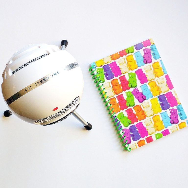 Colorful doodle notebook and vintage style microphone for podcasting or creative projects.